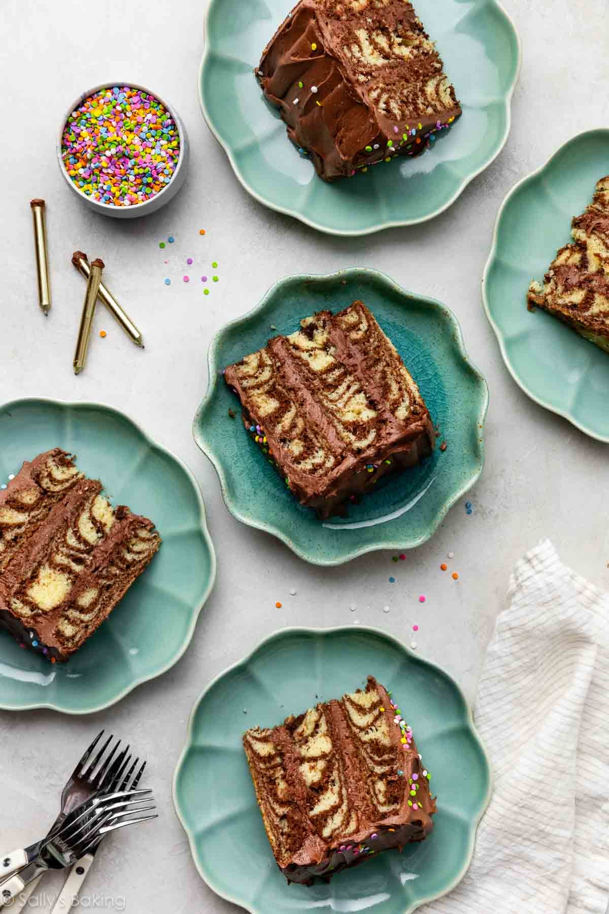 slices of zebra layer cake on aqua blue plates.