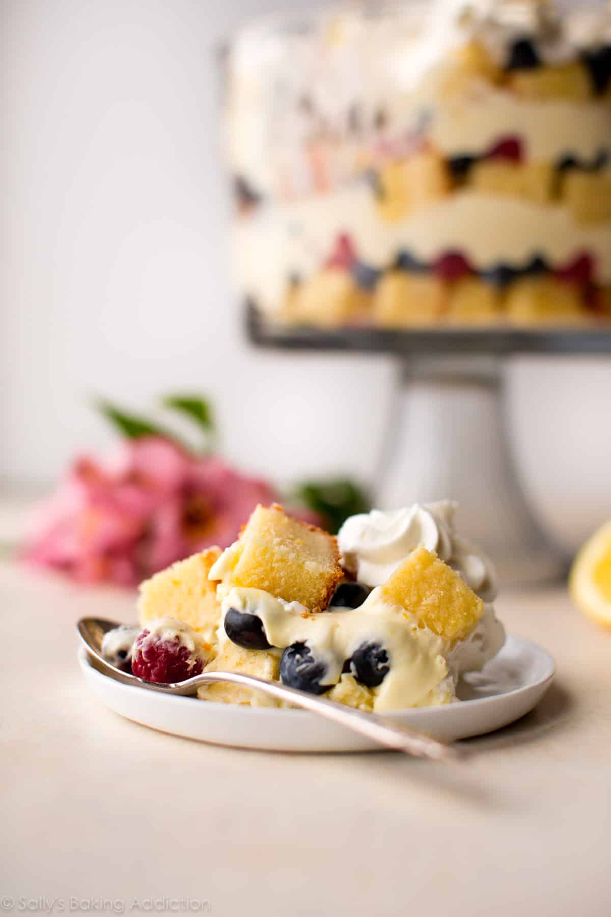 serving of lemon berry trifle on a white plate with a fork