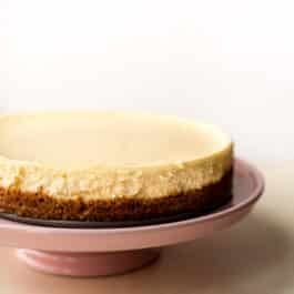 whole cheesecake on a pink cake stand