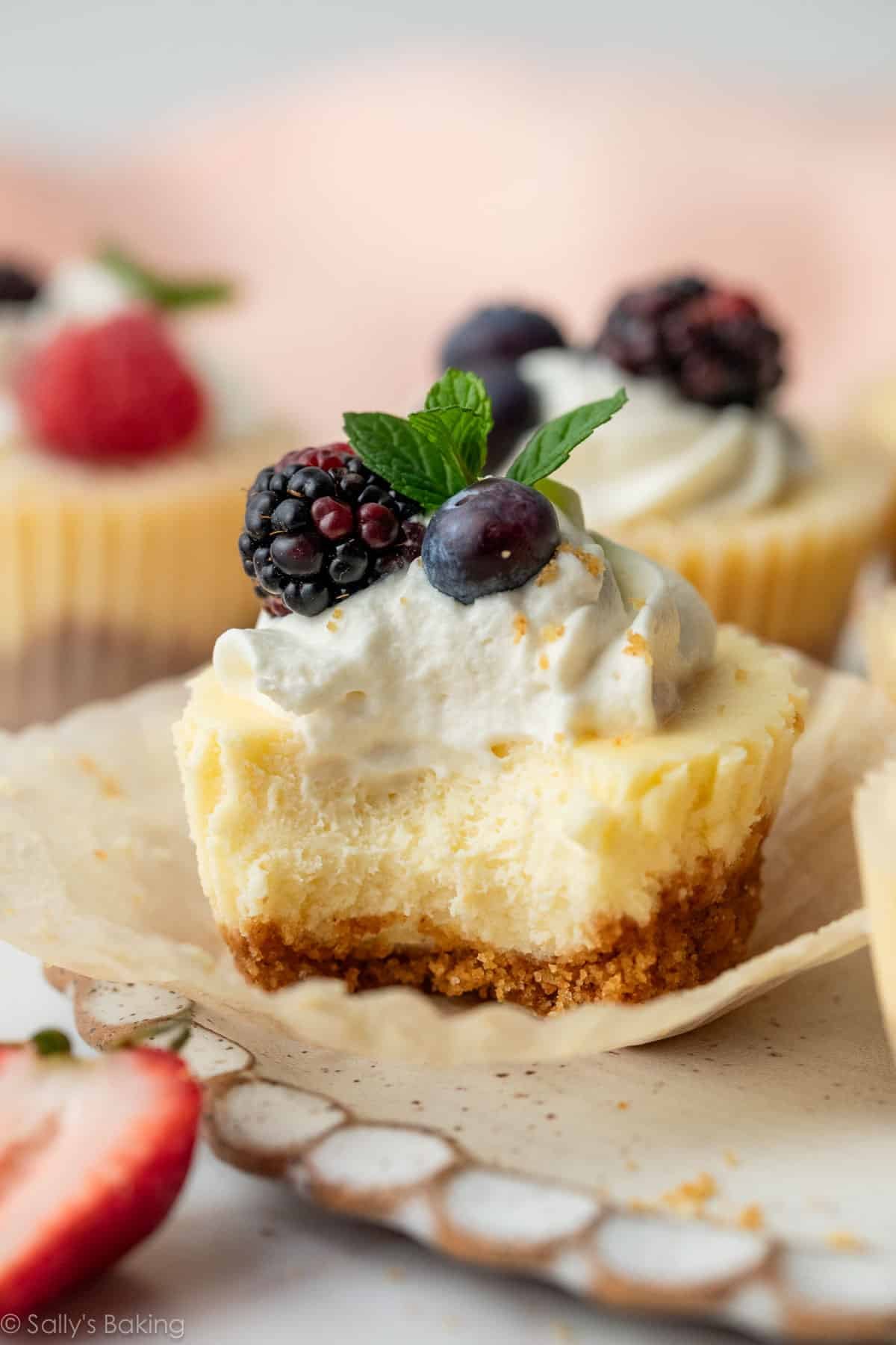 mini cheesecake with whipped cream and berries on top.