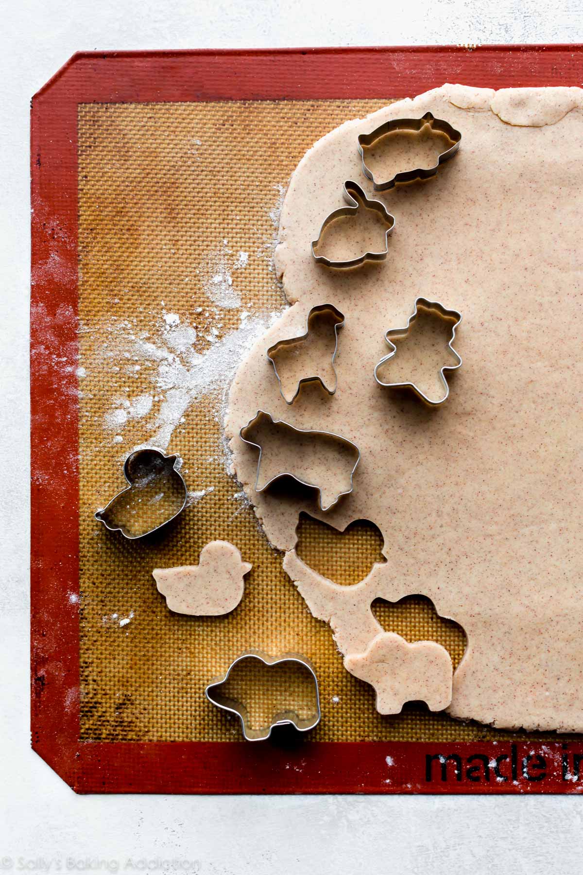 animal cracker cookie dough rolled out with animal cookie cutters