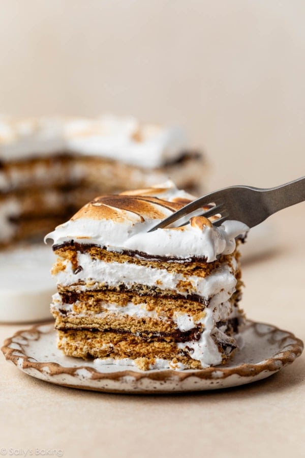 fork cutting through slice of s'mores cake.