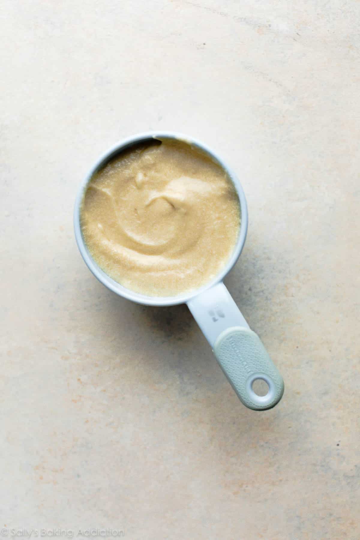 yellow cake batter in a 1 cup measuring cup