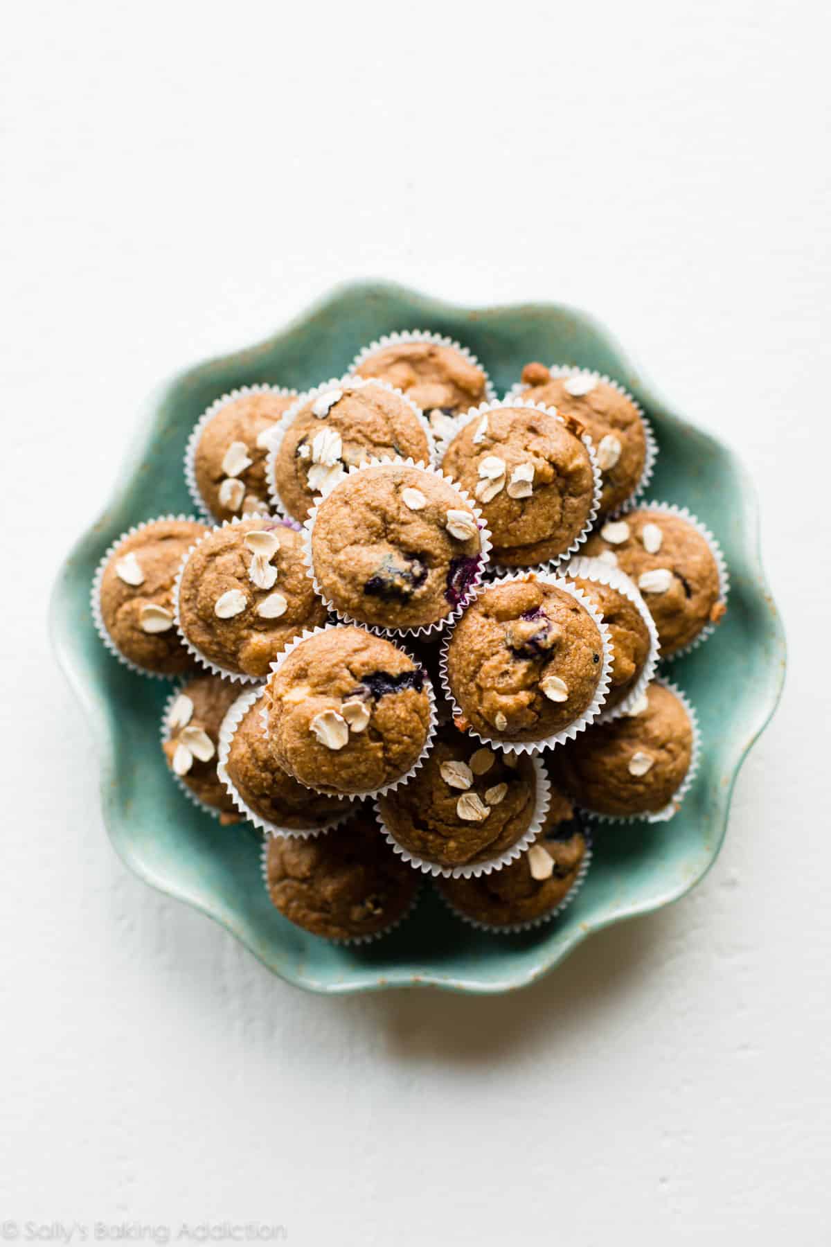 overhead image of baby muffins stacked on a teal plate