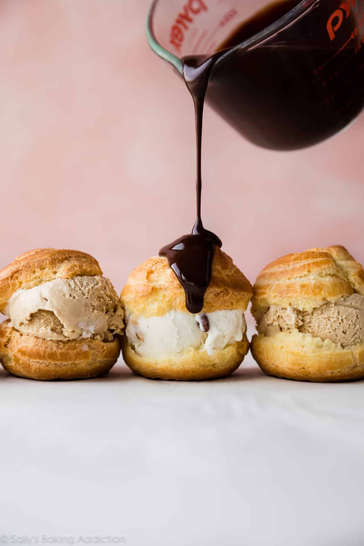 pouring chocolate ganache onto profiteroles