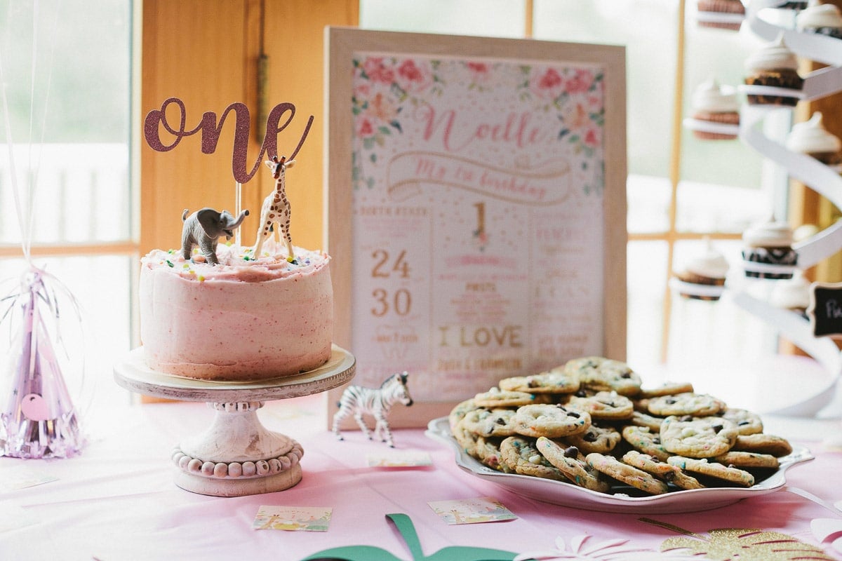 1st birthday cake and desserts on a decorated party table