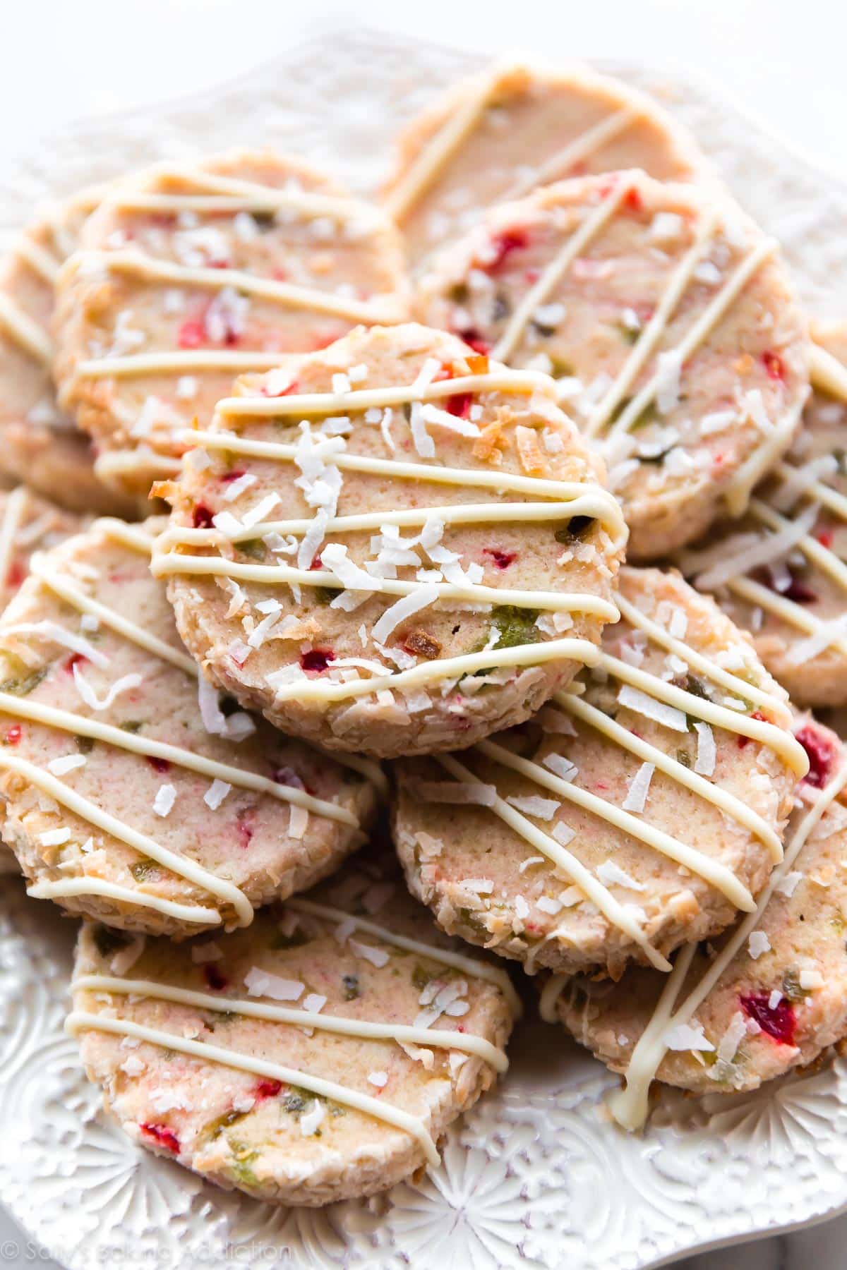 Santa's whiskers cookies with white chocolate drizzle on a white plate