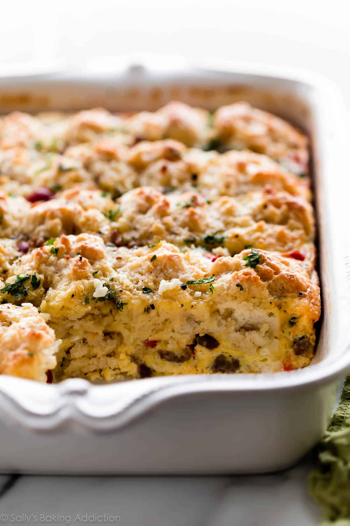 Sausage egg and cheese biscuit breakfast casserole in a white baking dish