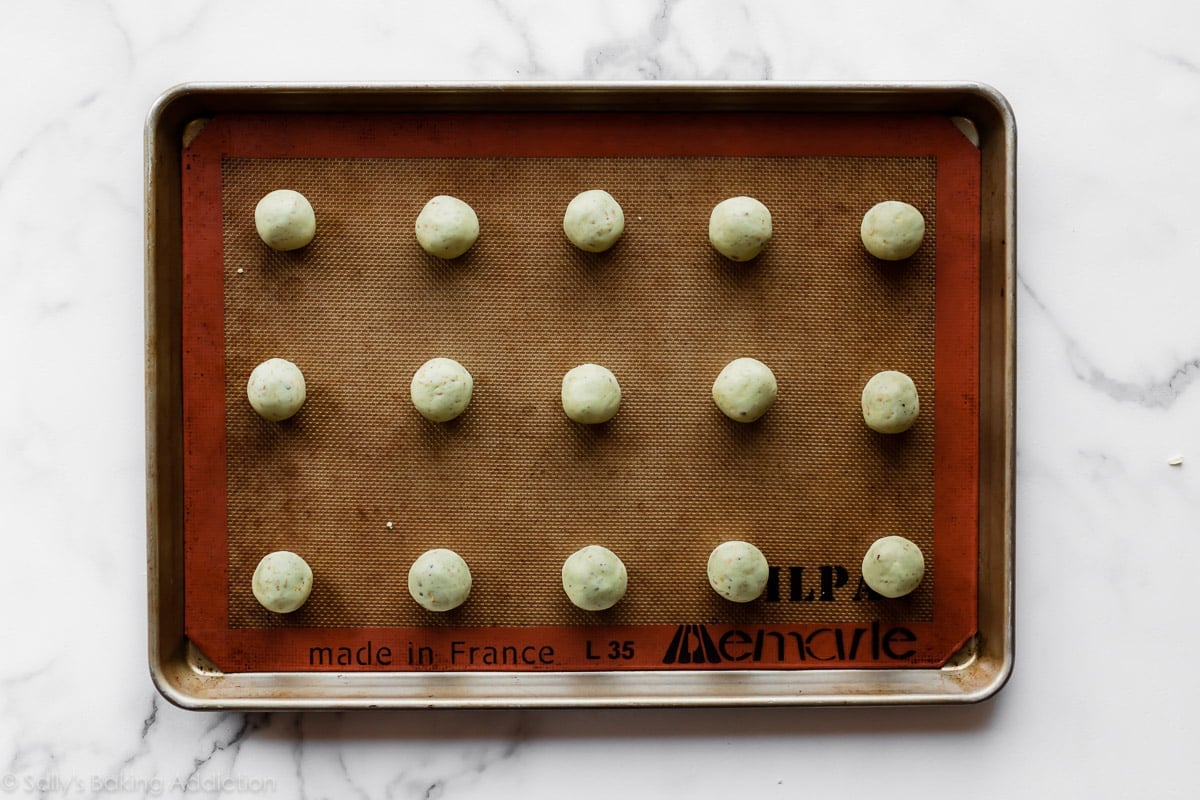 Pistachio drop cookie dough balls on baking sheet before baking