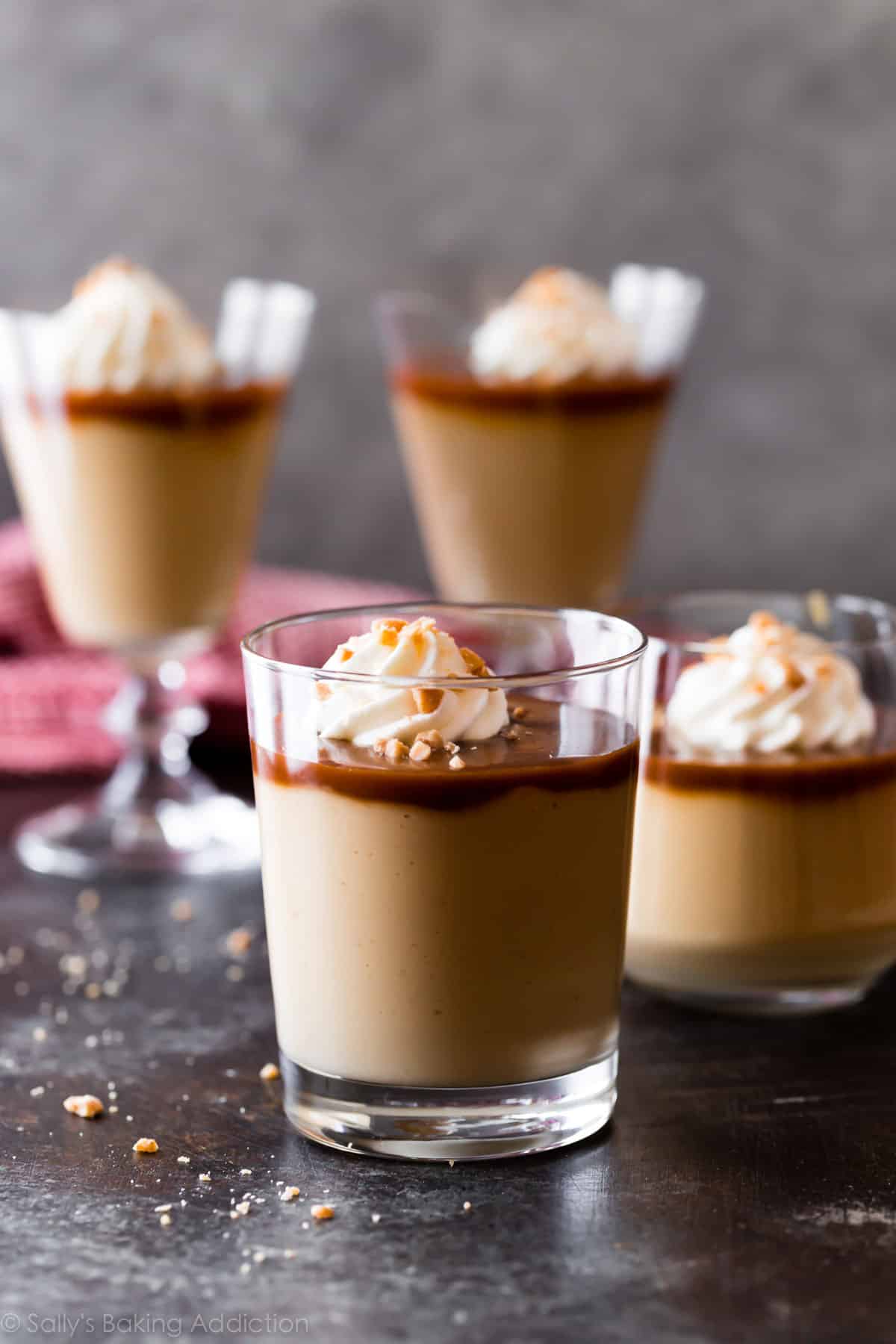 Homemade butterscotch pudding with salted caramel and whipped cream in glass cups