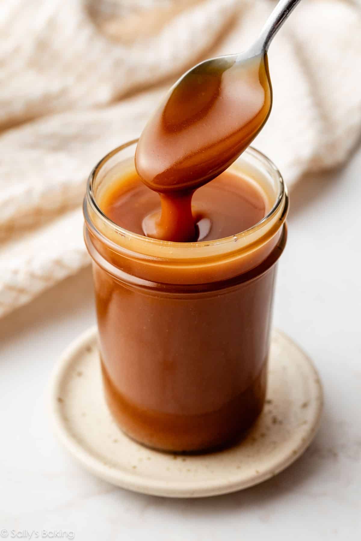 spoonful of salted caramel sauce coming out of a jar.