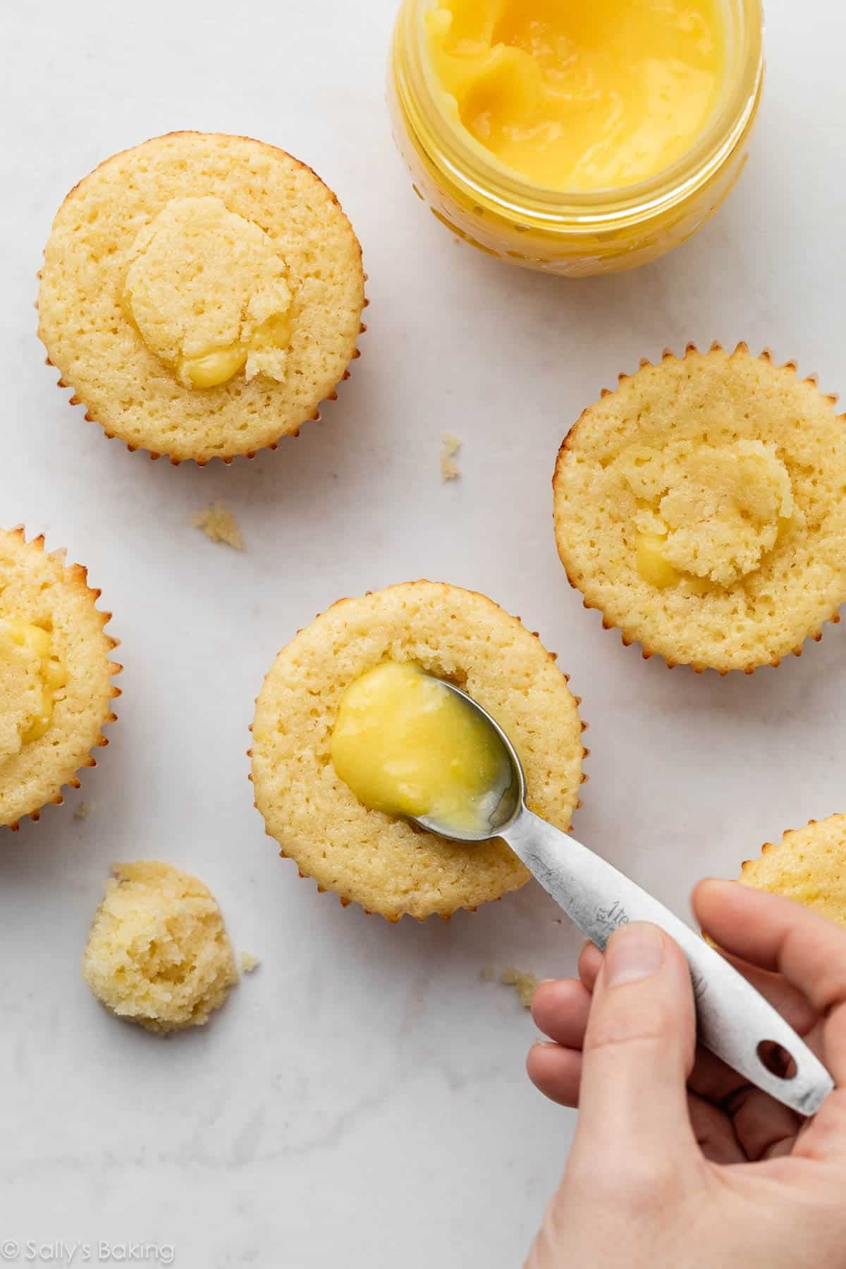 filling cupcakes with lemon curd.
