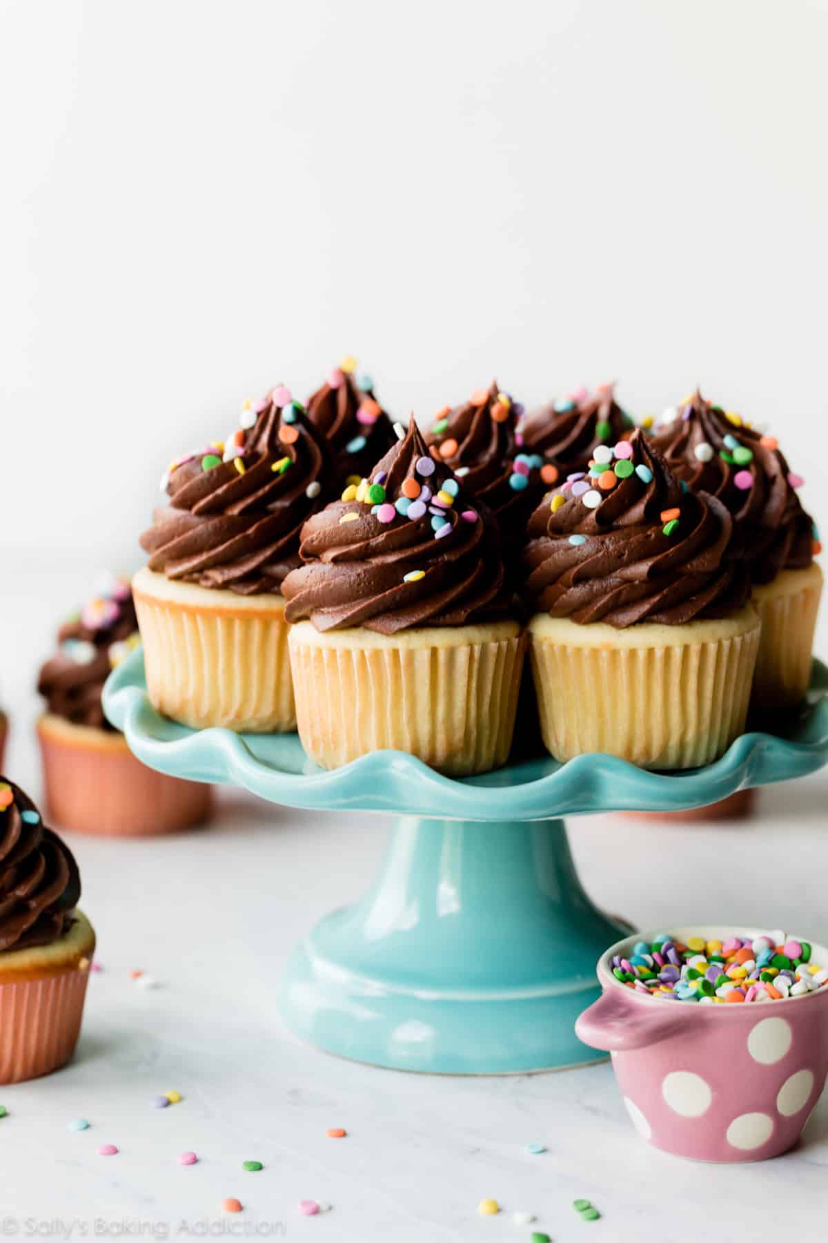 Yellow birthday cupcakes on blue cake stand