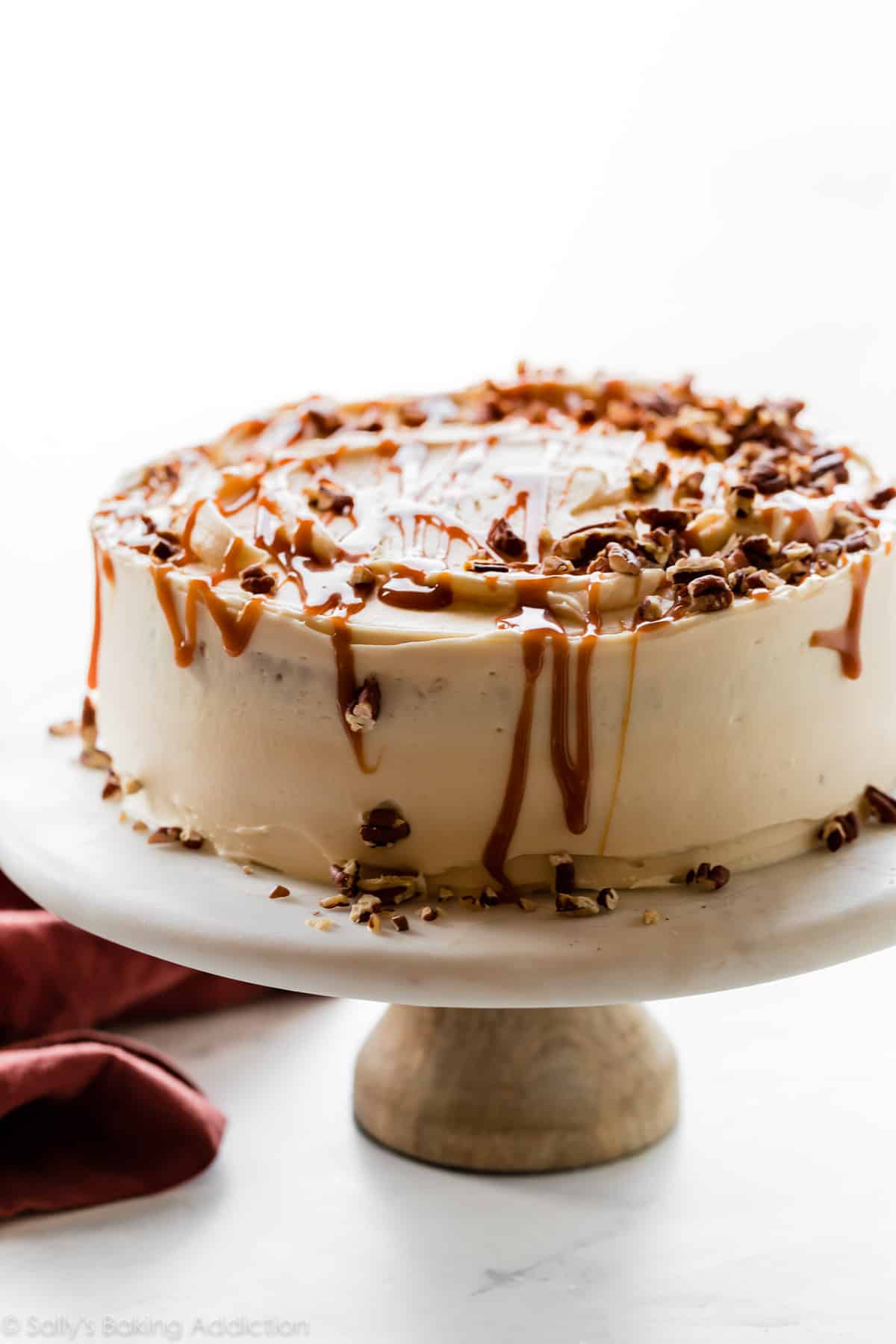 decorated burnt sugar caramel cake on a marble cake stand