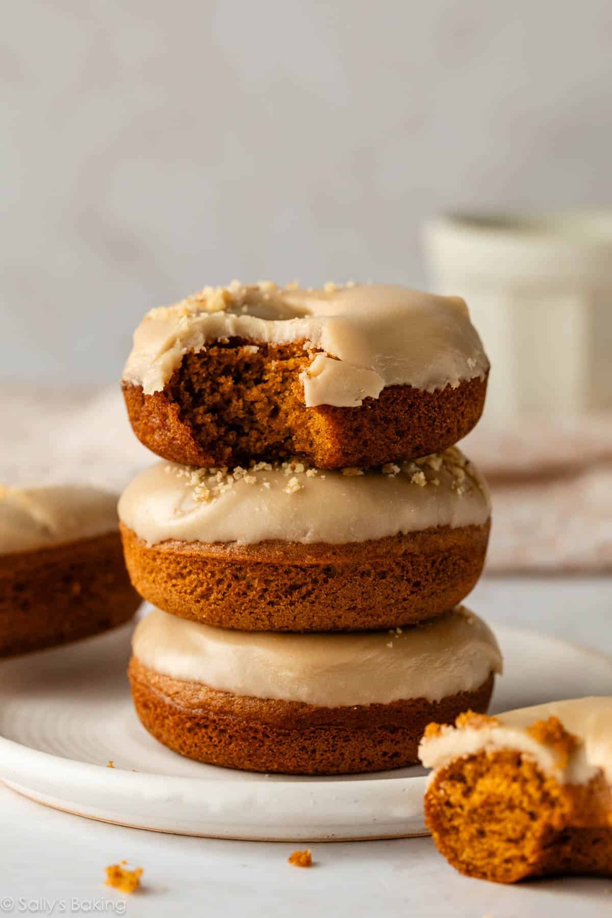 stack of 3 pumpkin donuts with brown sugar icing.