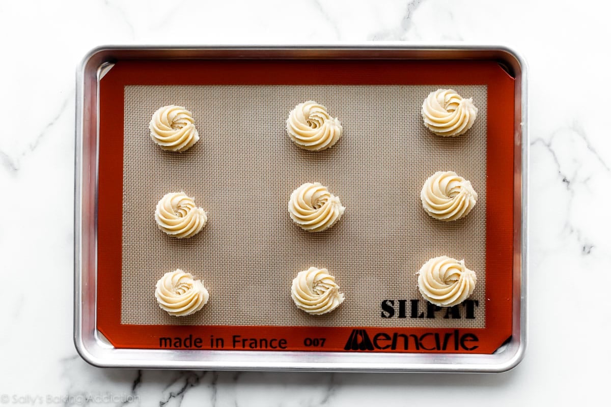 piped butter cookie dough on baking sheet