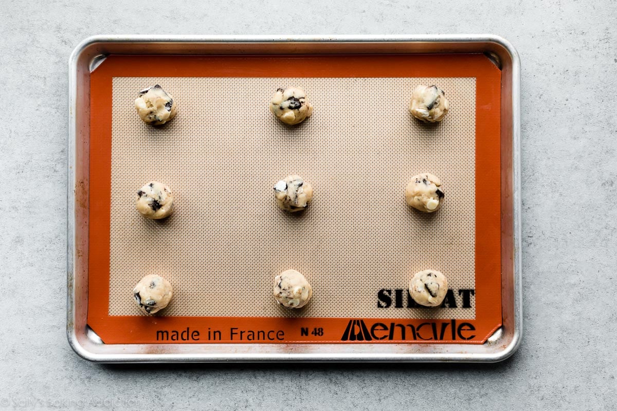 cookies and cream cookie dough balls on lined baking sheet