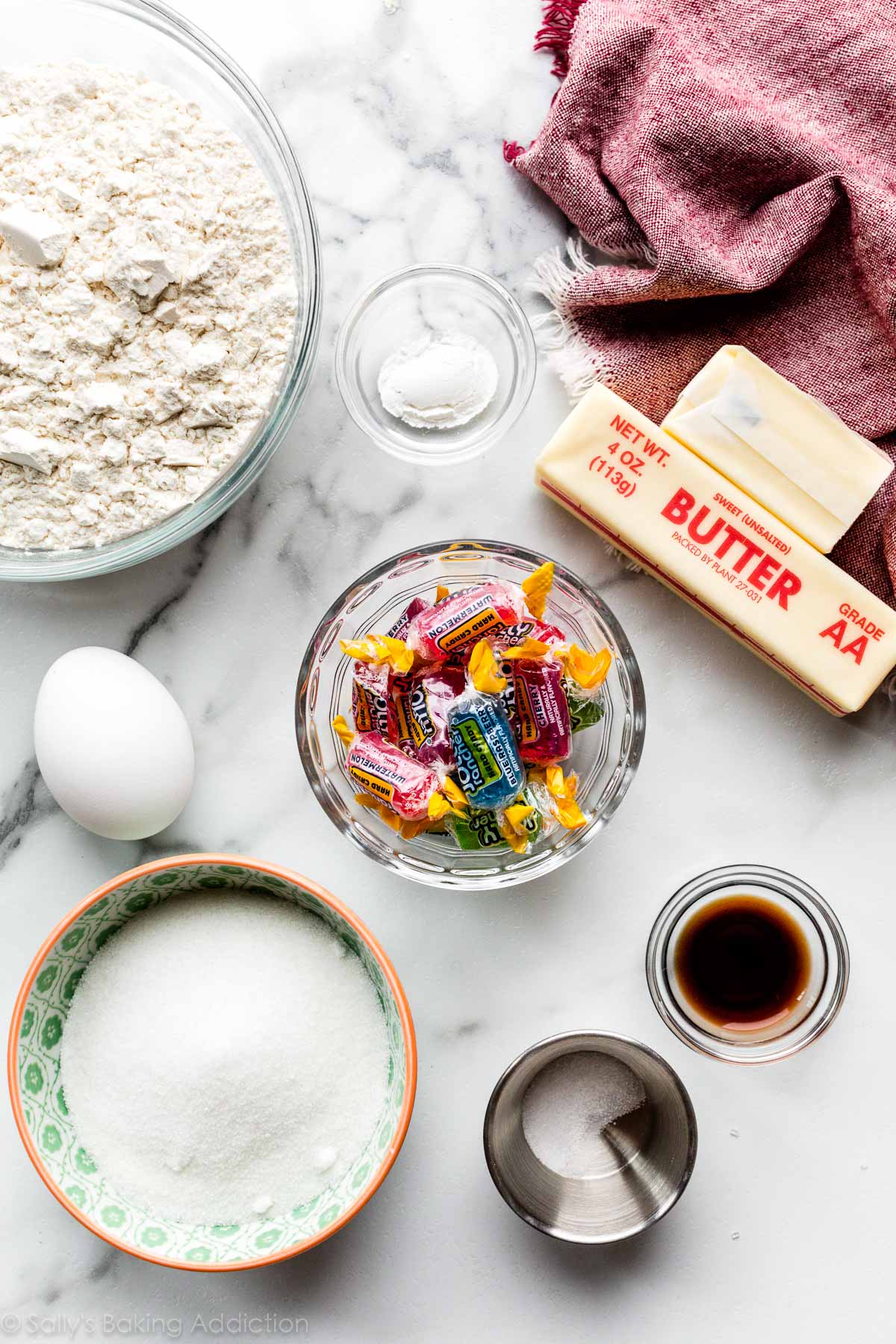 overhead photo of cookie ingredients including butter, sugar, flour, egg, and jolly rancher candies