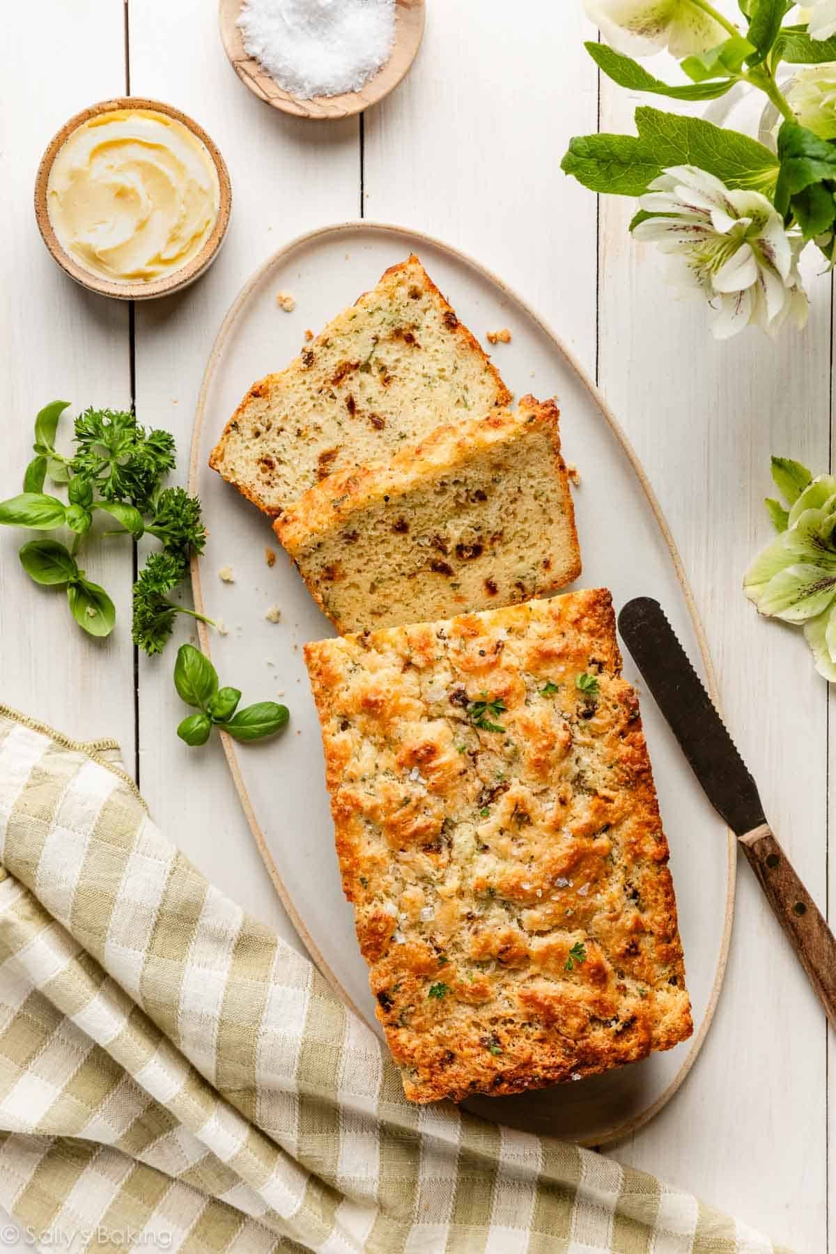 savory quick bread on oval plate with basil and parsley.