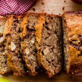 slices of apple cinnamon bread on wooden cutting board.