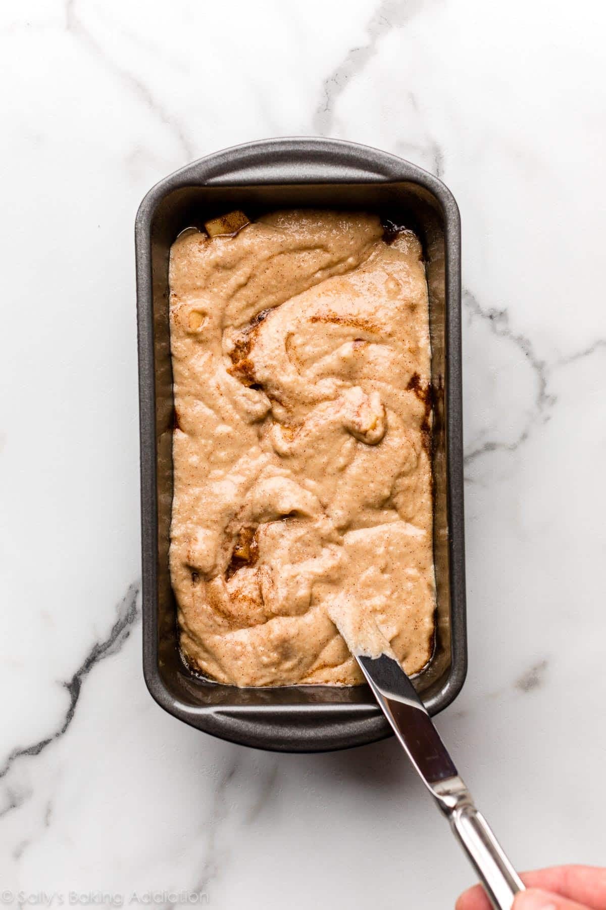 swirling apple cinnamon batter in the loaf pan