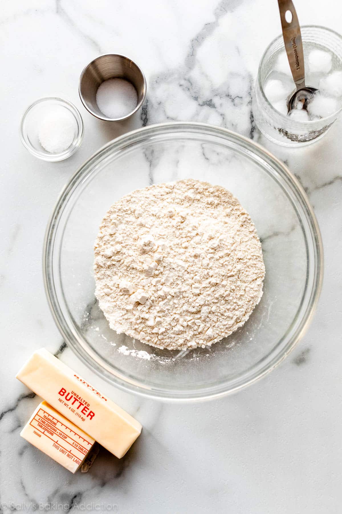 big bowl of flour with other ingredients around it