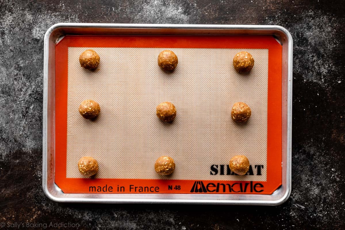 gingerbread oatmeal cookie dough balls on lined baking sheet