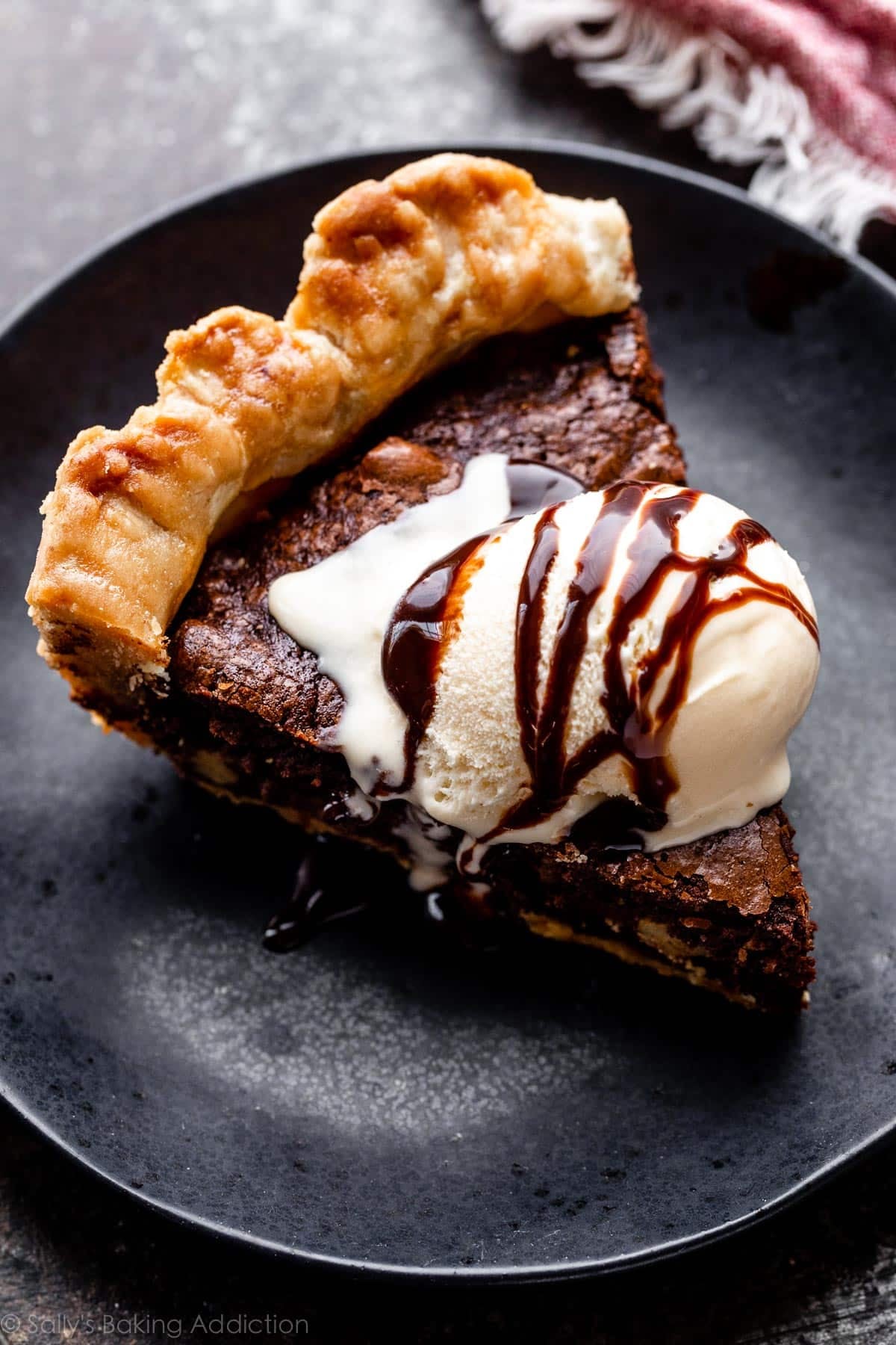 slice of brownie pie with vanilla ice cream and chocolate syrup