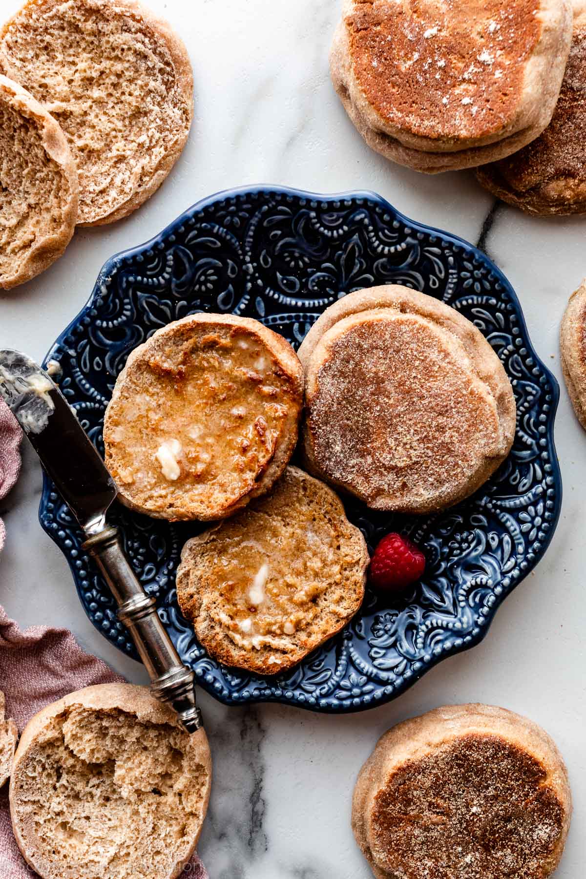 toasted homemade English muffin with butter on blue plate