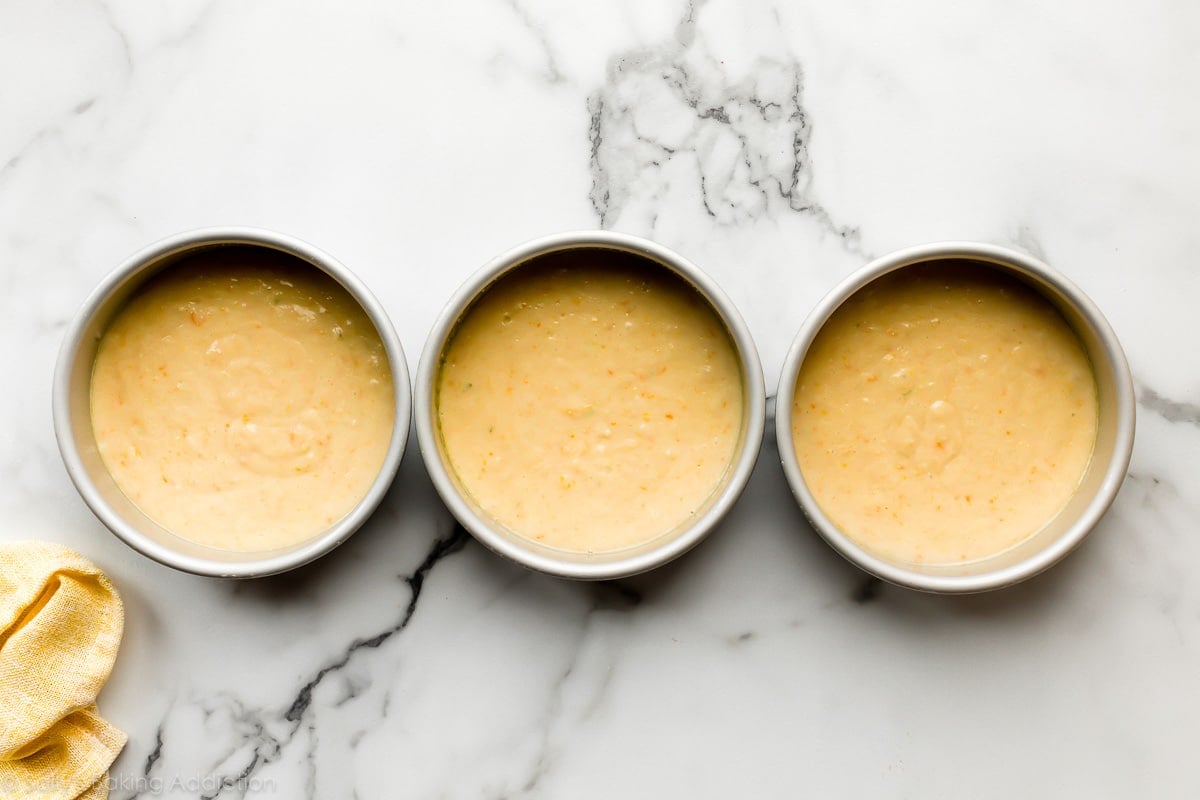 3 6 inch cake pans filled with cake batter