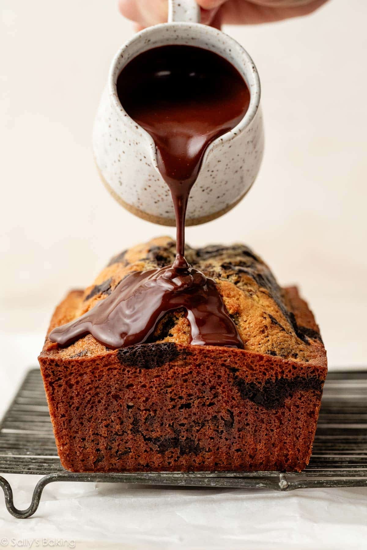 pouring ganache on loaf cake.