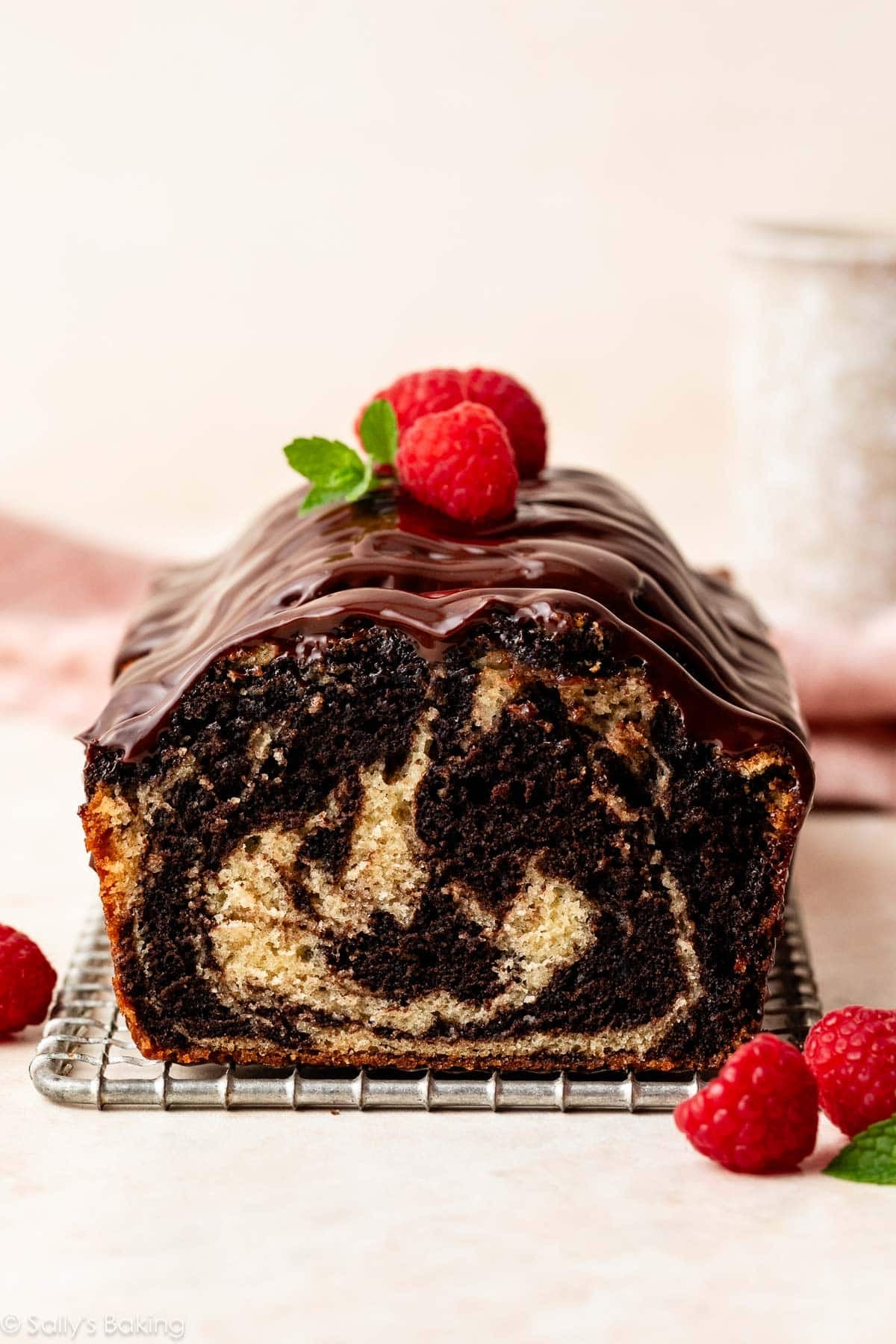 marble loaf cake with ganache and fresh raspberries on top.