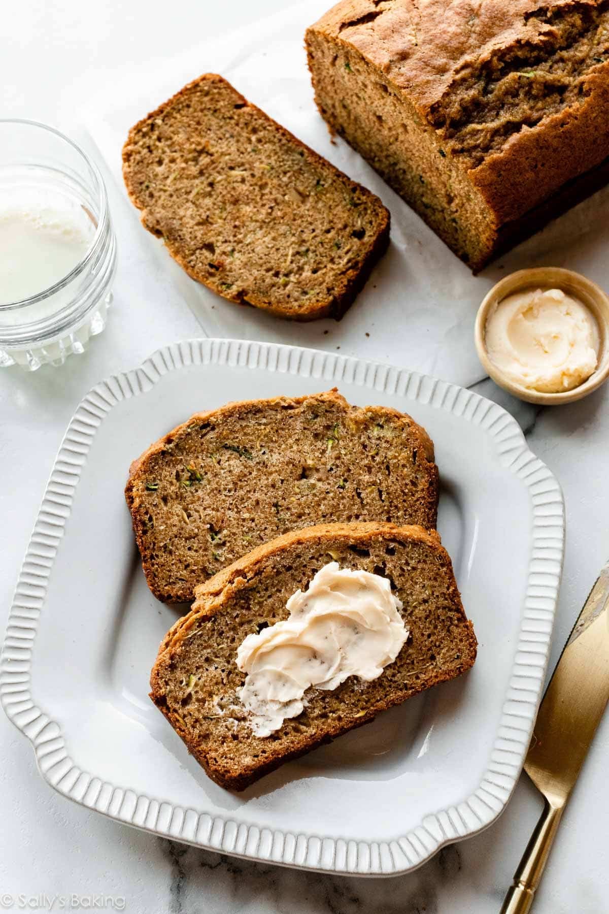 2 slices zucchini bread with butter on plate.
