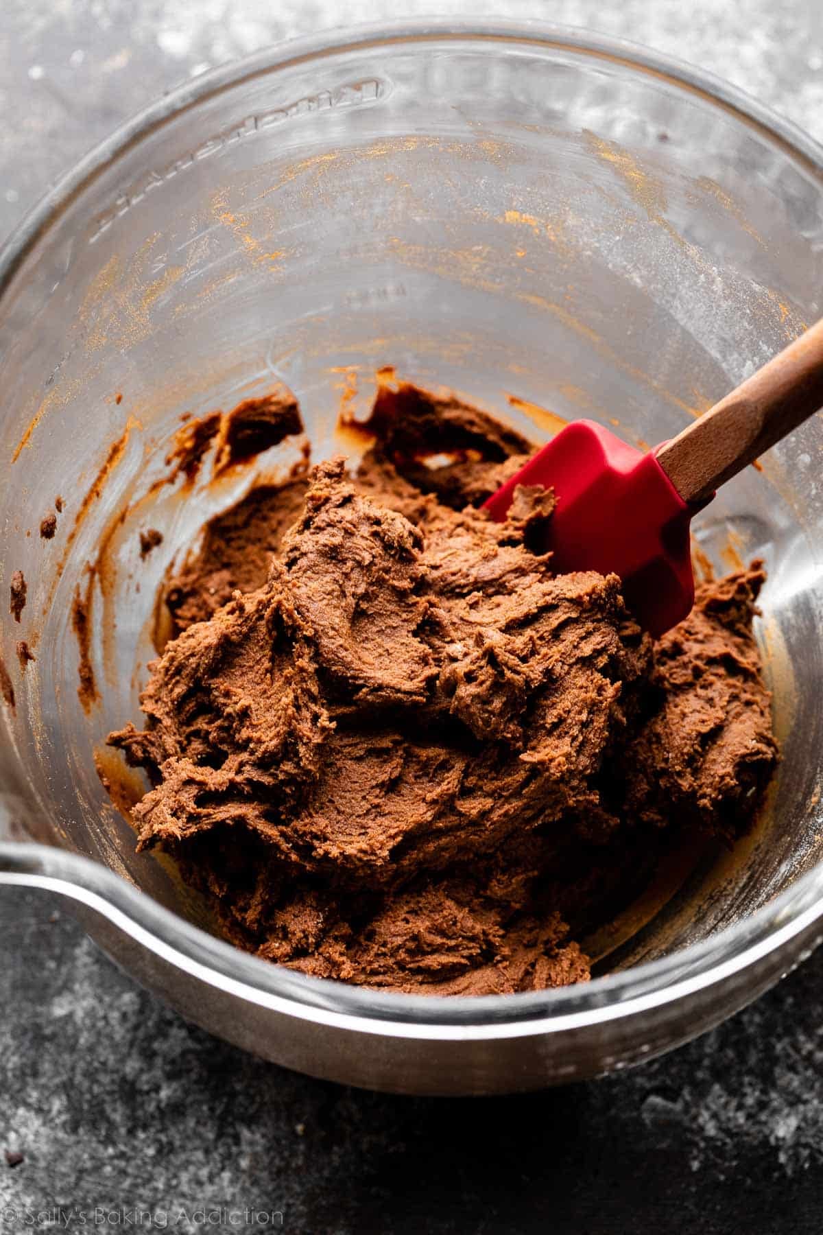 chocolate cookie dough in glass bowl on dark gray countertop.