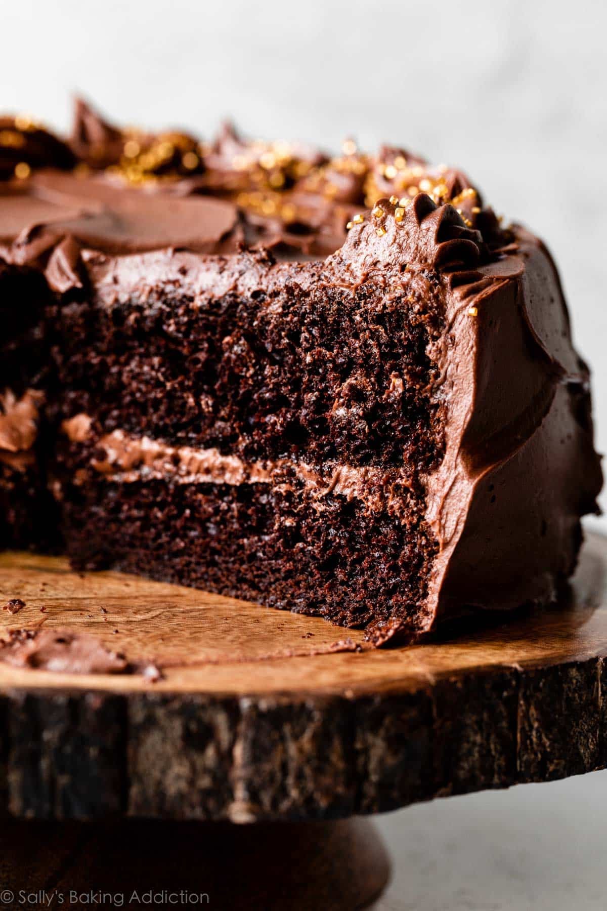 Guinness chocolate cake cut open on wooden cake stand.