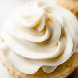 close-up image of white chocolate buttercream swirled on a cupcake.
