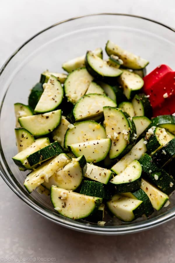 cut zucchini with garlic in glass bowl.