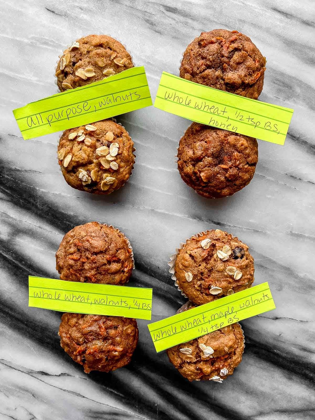 muffins with some oats on top of 4 of them with green pieces of paper on top indicating ingredients.