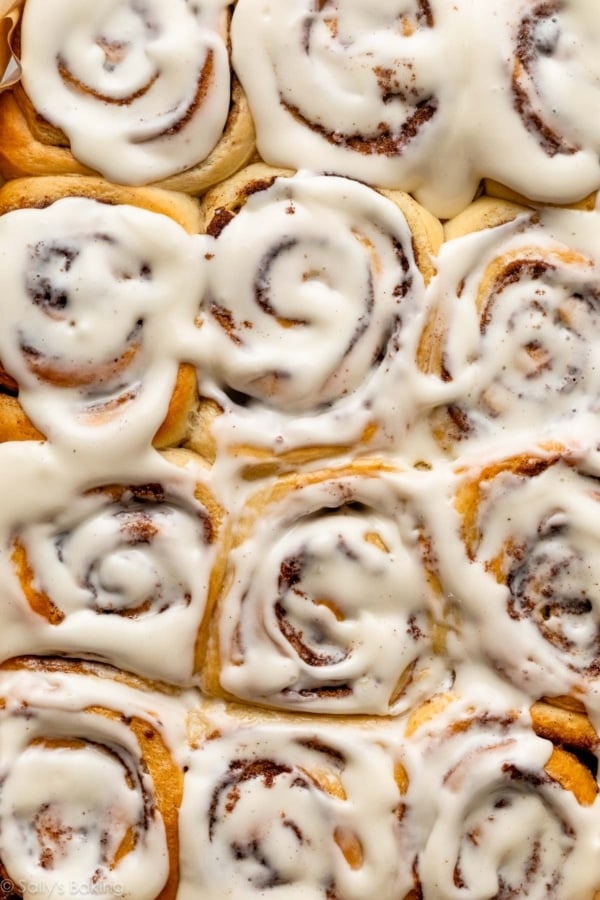 close-up pan of baked and frosted cinnamon rolls.