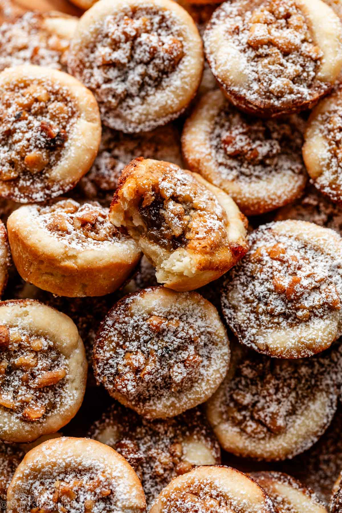 close-up of maple walnut tassies with one with bite taken out.
