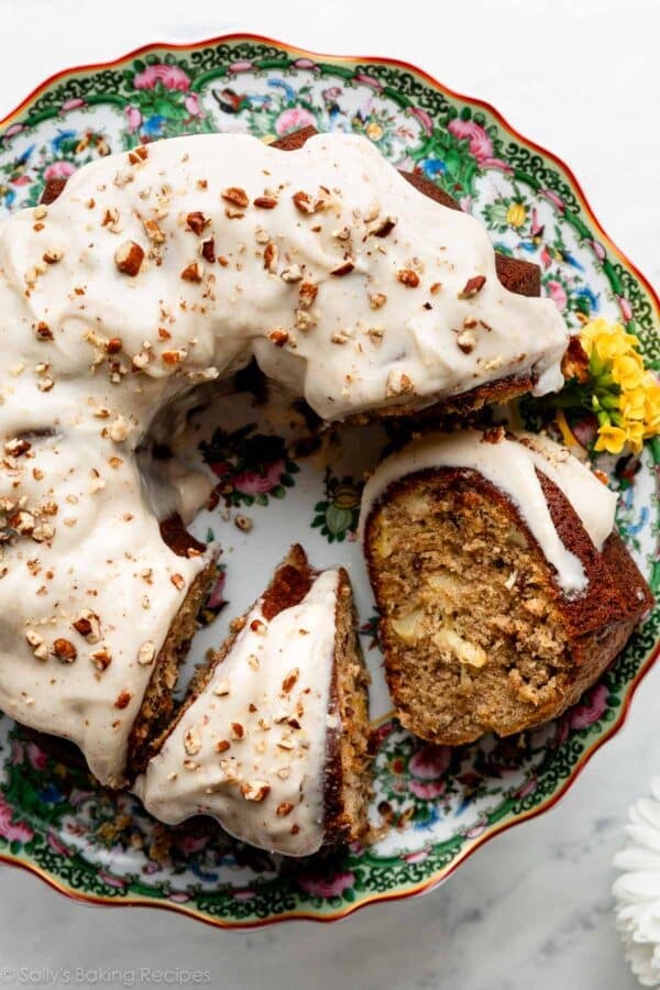 pineapple and banana Bundt cake cut with 2 slices on a green and pink floral cake stand.