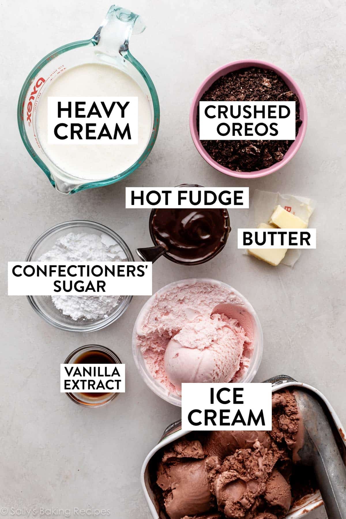 ingredients measured in bowls including heavy cream, Oreos, hot fudge, butter, and confectioners sugar.