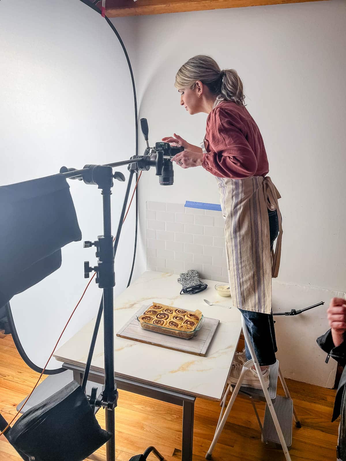 behind-the-scenes photo of Sally taking photo of cinnamon rolls.