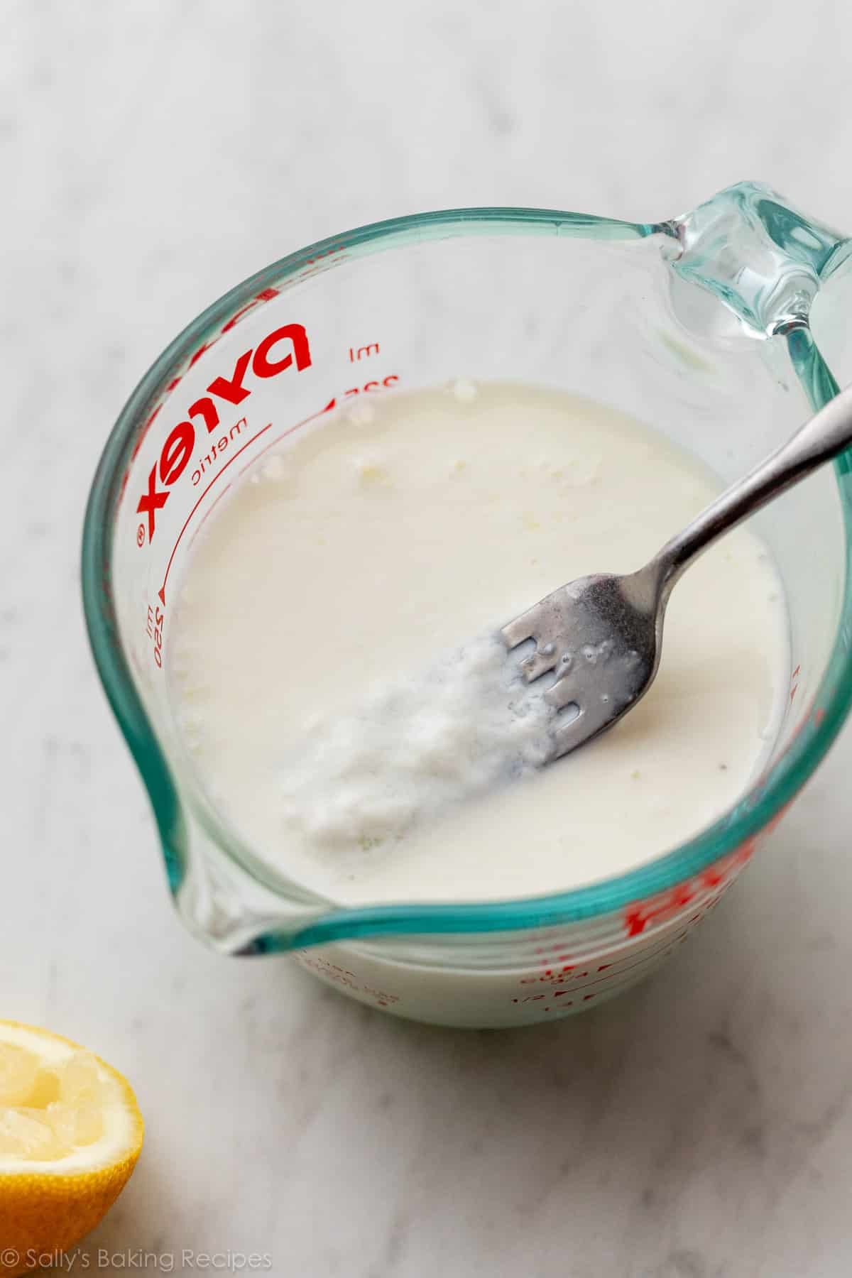 diy buttermilk with fork in liquid measuring cup.