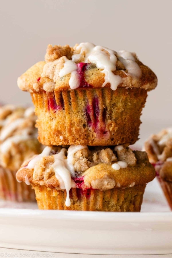 stack of 2 cranberry crumb orange muffins with icing on top.