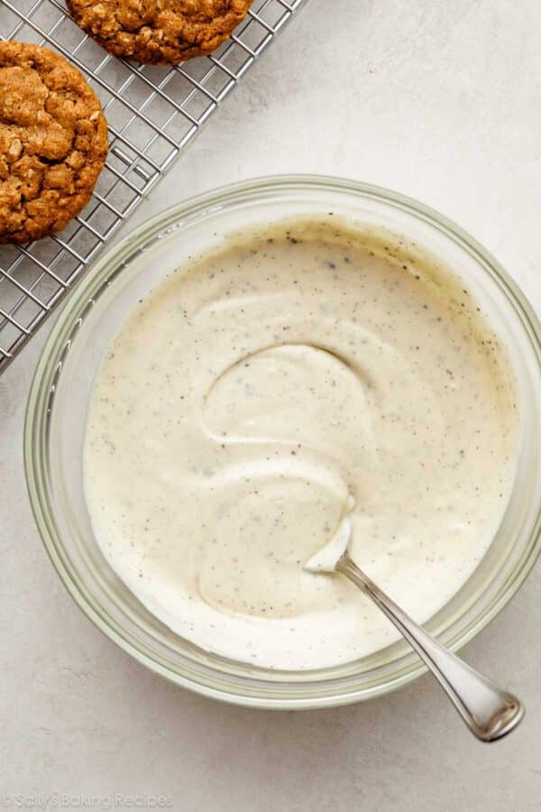 espresso powder speckled melted white chocolate in a glass bowl.