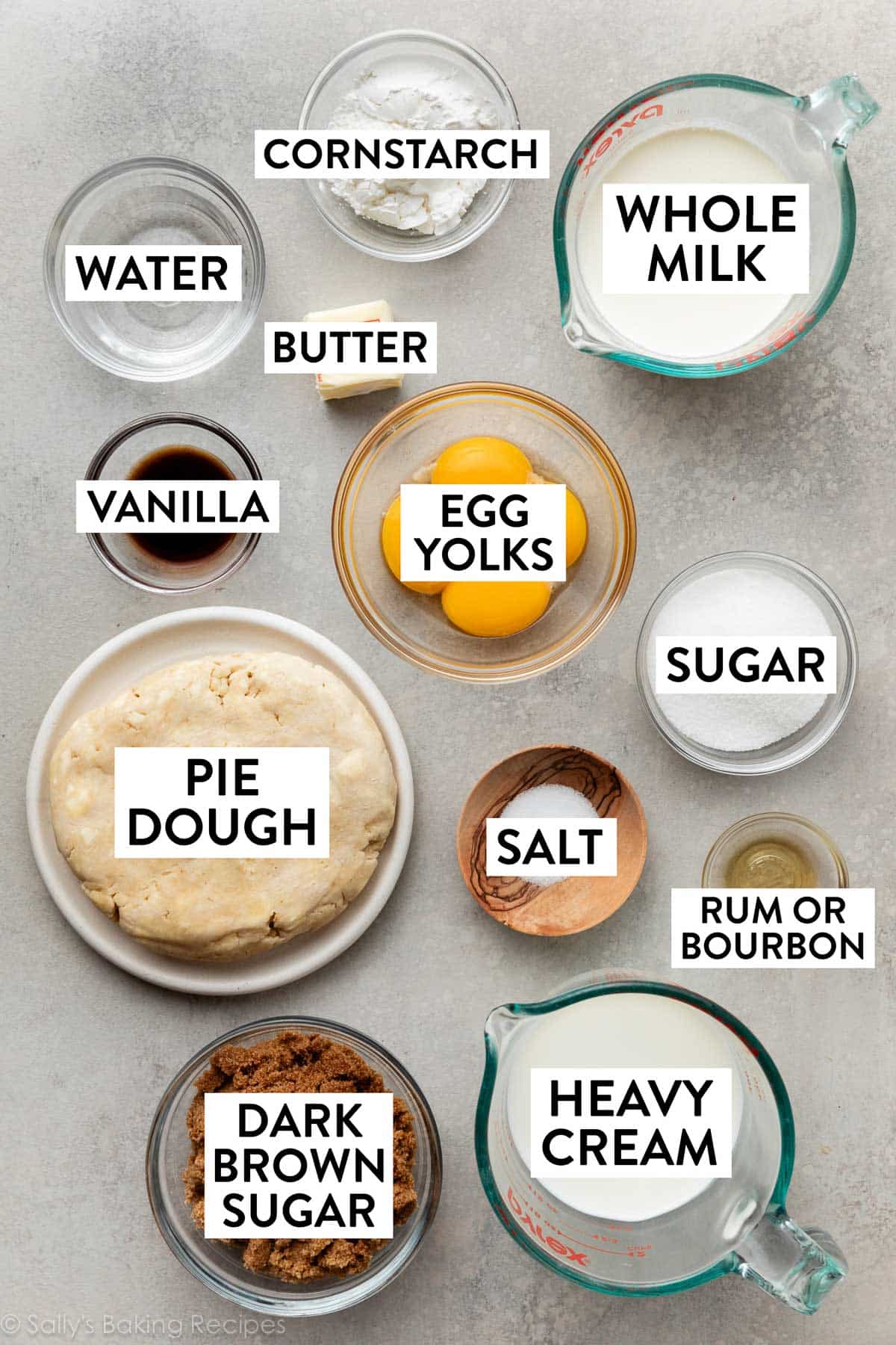 ingredients on surface including milk, egg yolks, heavy cream, dark brown sugar, vanilla, salt, water, and butter.