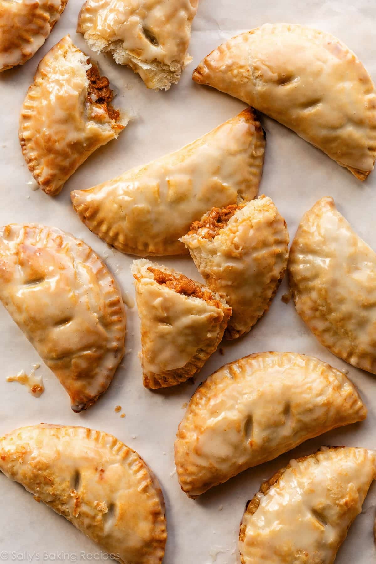 glazed pumpkin hand pies on parchment paper.