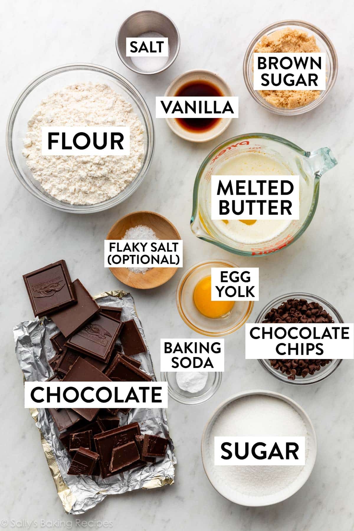 ingredients on counter including flour, melted butter, brown sugar, vanilla, chocolate, egg yolk, and baking soda.