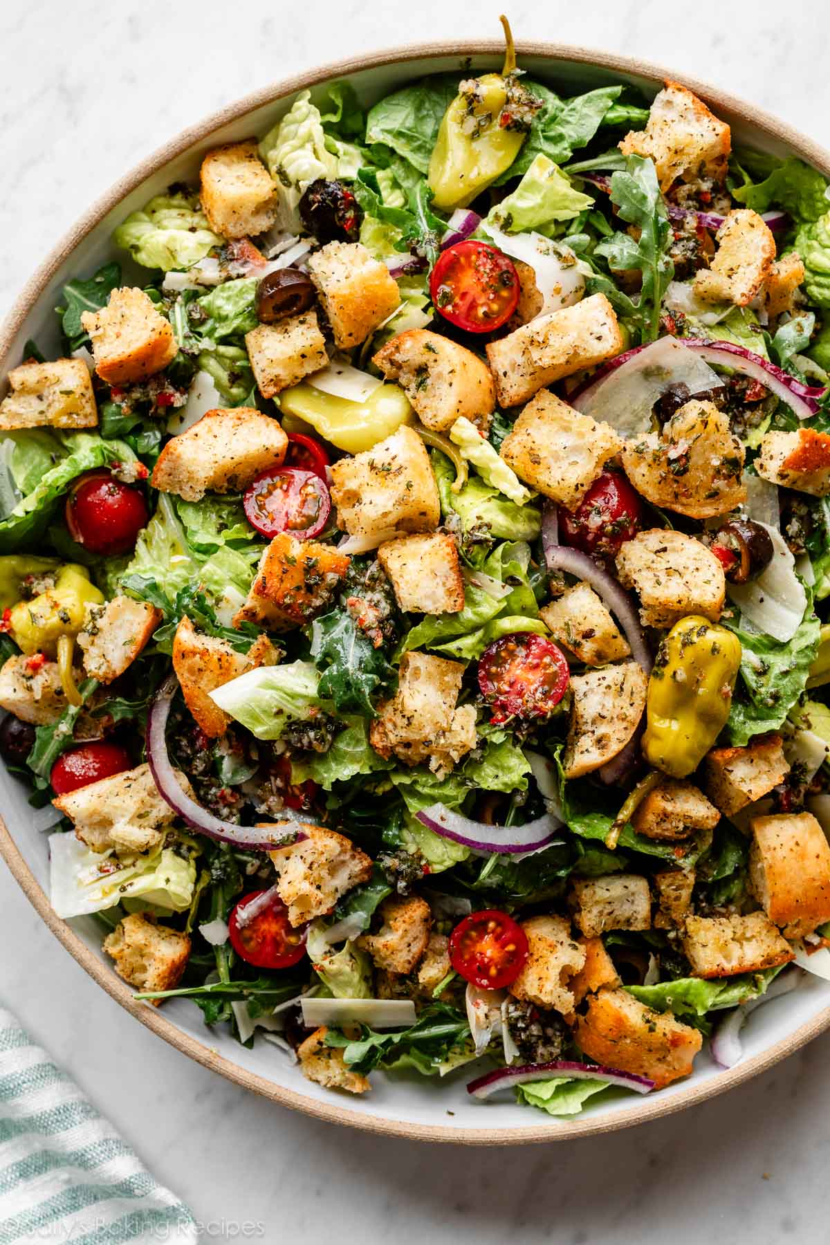 Italian-style salad with homemade croutons and dressing on top.